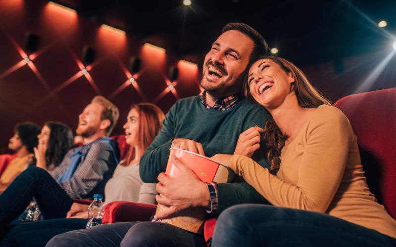 Zdjęcie przedstawia szczęśliwą parę, która znajduje się w kinie