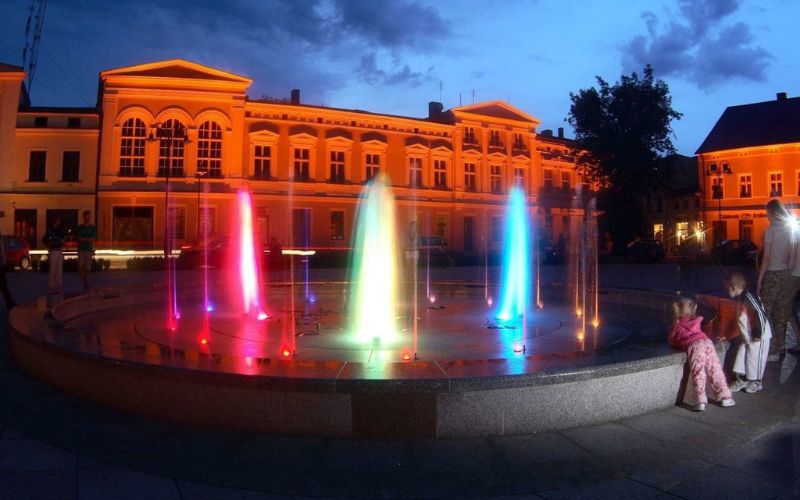 Zdjęcie przedstawia kolorową fontannę na rynku w Wągrowcu
