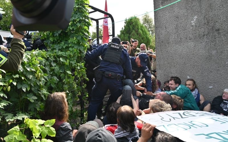 Eksmisja na Osiedlu Maltańskim w Poznaniu – policjanci interweniują wobec protestujących siedzących na ziemi i blokujących wejście.